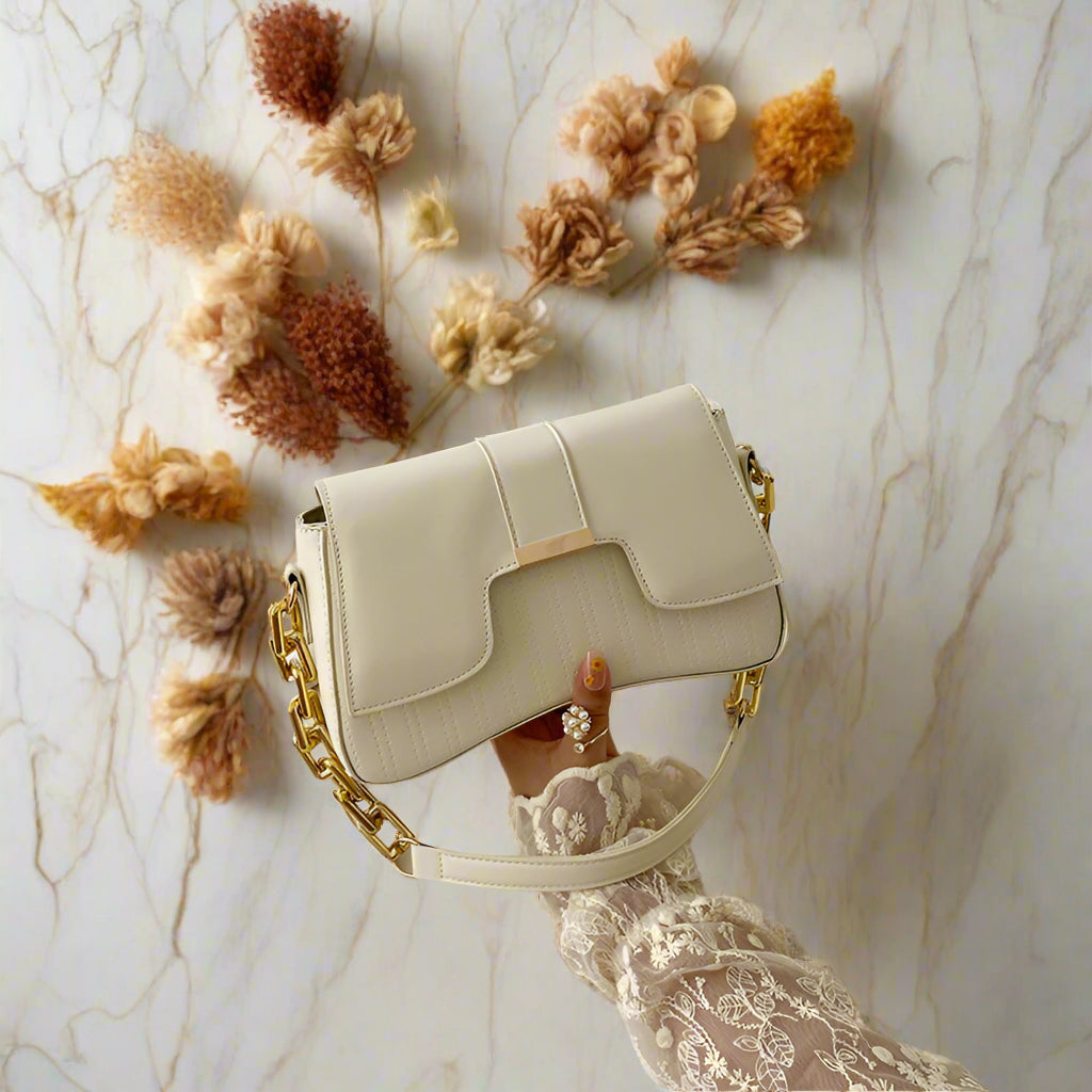 Light beige faux leather shoulder bag with soft body and minimal details.
